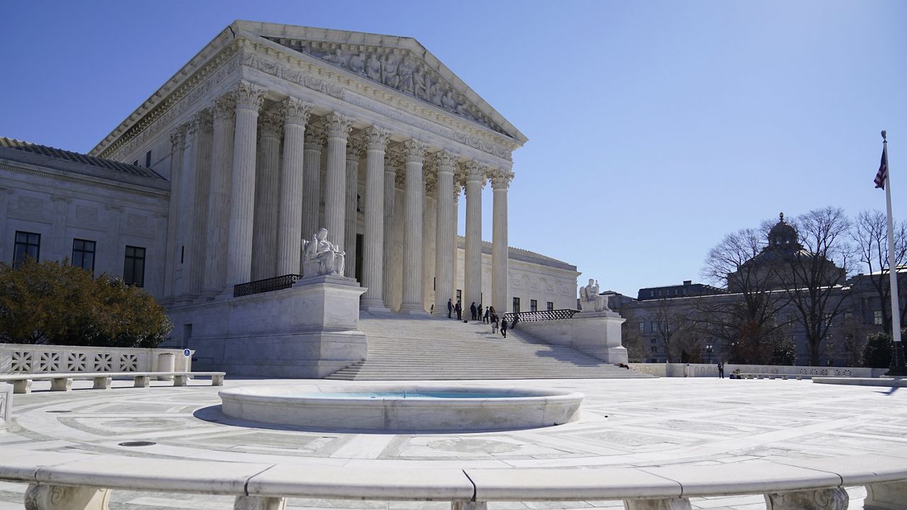 People stand on the steps of the U.S. Supreme Court, Feb.11, 2022, in Washington. (AP Photo/Mariam Zuhaib)