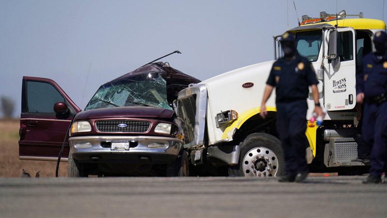 In this Tuesday, March 2, 2021, file photo, law enforcement officers work at the scene of a deadly crash in Holtville, Calif. Nine migrants in an SUV packed with 25 people that drove through an opening in a border wall suffered major injuries after their vehicle slammed into a tractor-trailer and killed 13 others inside, the California Highway Patrol said Thursday, March 4, 2021. (AP Photo/Gregory Bull, File)