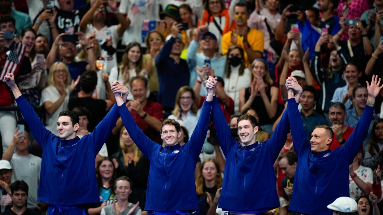 The United States men's 4x100-meter freestyle relay team celebrate as they stand on the podium after winning the gold medal at the 2024 Summer Olympics, Saturday, July 27, 2024, in Nanterre, France. 