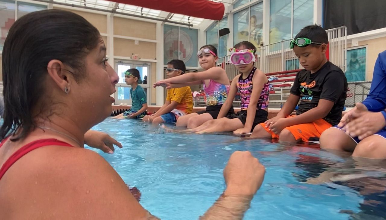 Virginia Rodríguez, head instructor and child drowning survivor, teaches kids how to swim. (photo credit: Adolfo Muniz/Spectrum News 1)