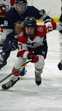 Sydney Stoughton races up the ice ahead of a defender trying to beat her to the puck in a youth hockey games (Provided)