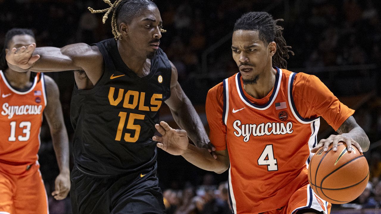 chris bell of syracuse, at right, drives toward basket, with possession of ball, as tennessee defender tries to cut him off