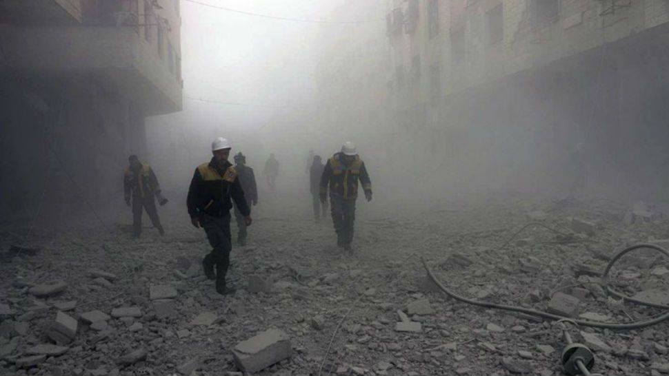 This photo provided by the Syrian Civil Defense group shows civil defense workers searching for survivors after airstrikes hit a rebel-held suburb near Damascus, Syria. (Syrian Civil Defense White Helmets via AP)