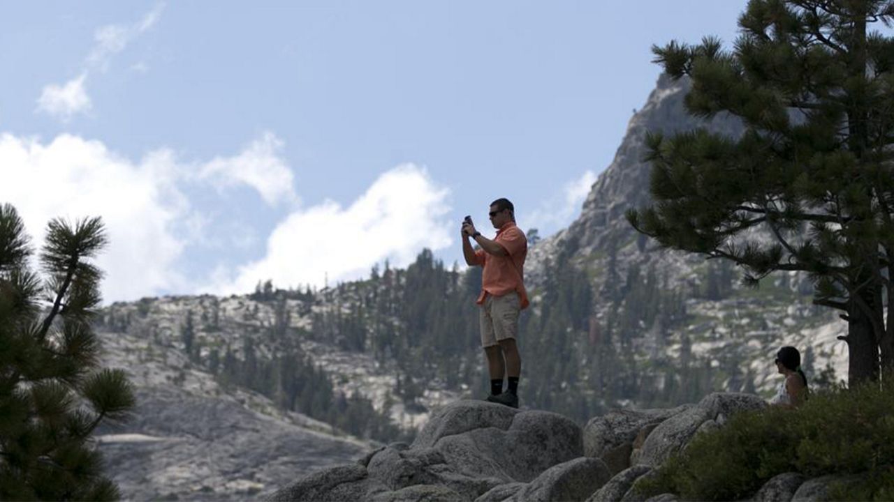 In this Aug. 8, 2017 file photo, a man gets a scenic view of Emerald Bay near South Lake Tahoe, Calif.  (AP Photo/Rich Pedroncelli, File)
