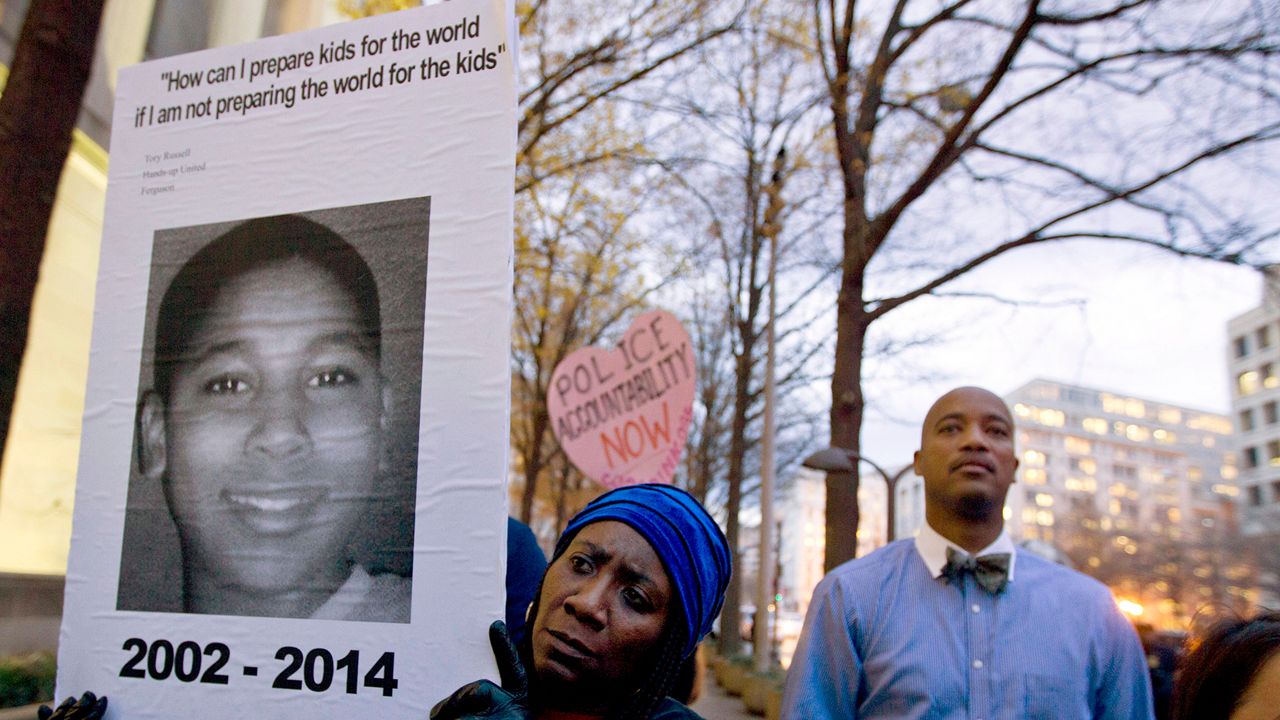 In a Monday, Dec. 1, 2014 file photo, Tomiko Shine holds up a picture of Tamir Rice during a protest in Washington, D.C. (AP Photo/Jose Luis Magana)