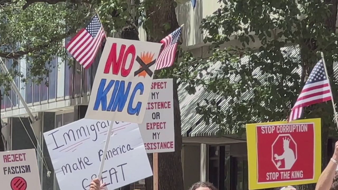 Signs held up at a protest in Tampa. (Spectrum News)
