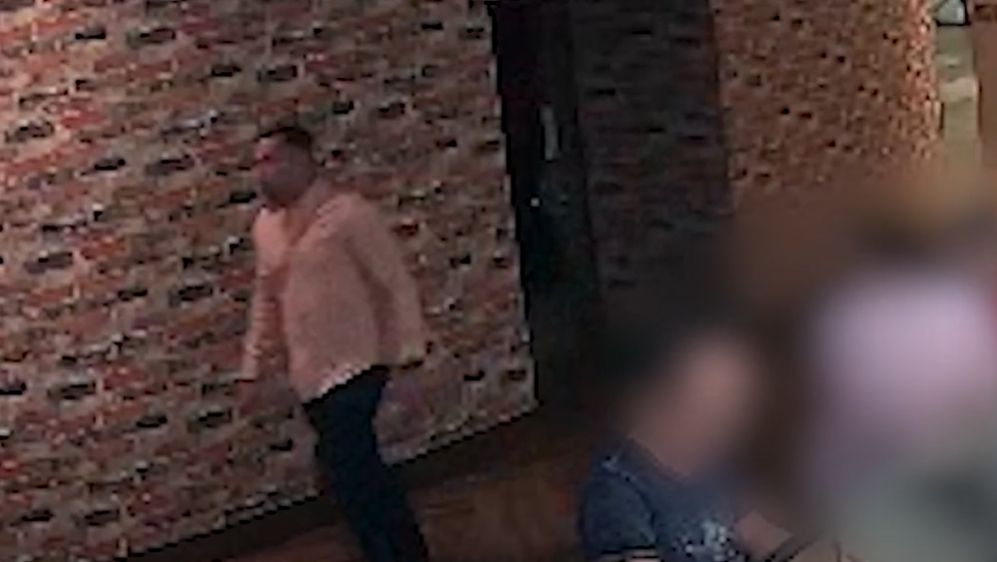 The suspect was described as a white or Hispanic male, with a possible Cuban accent. He appears to be in his 30s, 5’10-6’0”, has a muscular build with a belly, and some facial hair. He can be seen in a surveillance video wearing a long-sleeved pink shirt and blue jeans. (Tampa Police Department)