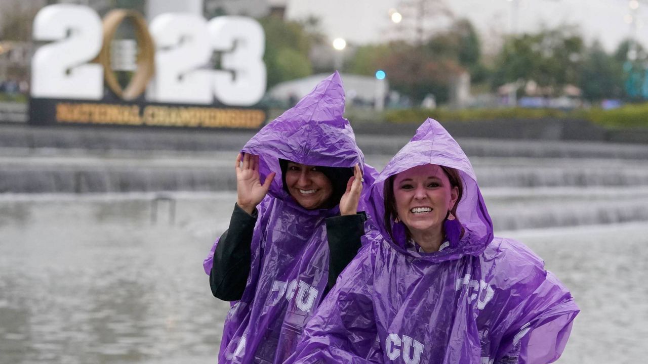 Fans struggle to put on ponchos in rain 