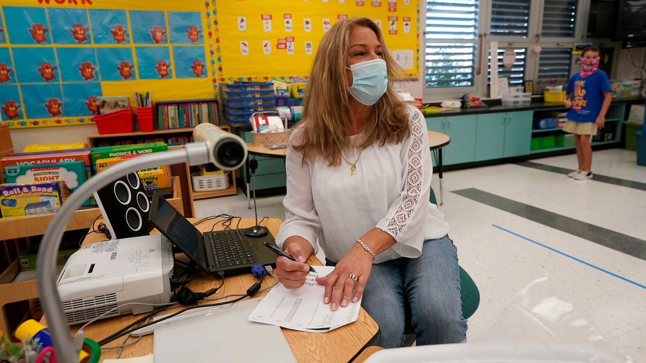 A file photo of a teacher wearing a mask in class