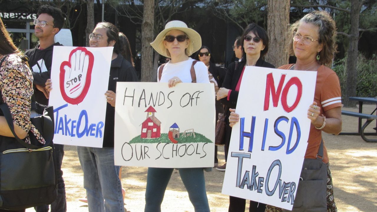 People hold up signs at a news conference, Friday, March 3, 2023, in Houston while protesting the proposed takeover of the city's school district by the Texas Education Agency. Texas officials on Wednesday, March 15, announced a state takeover of Houston's nearly 200,000-student public school district, the eighth-largest in the country, acting on years of threats and angering Democrats who assailed the move as political. (AP Photo/Juan A. Lozano)