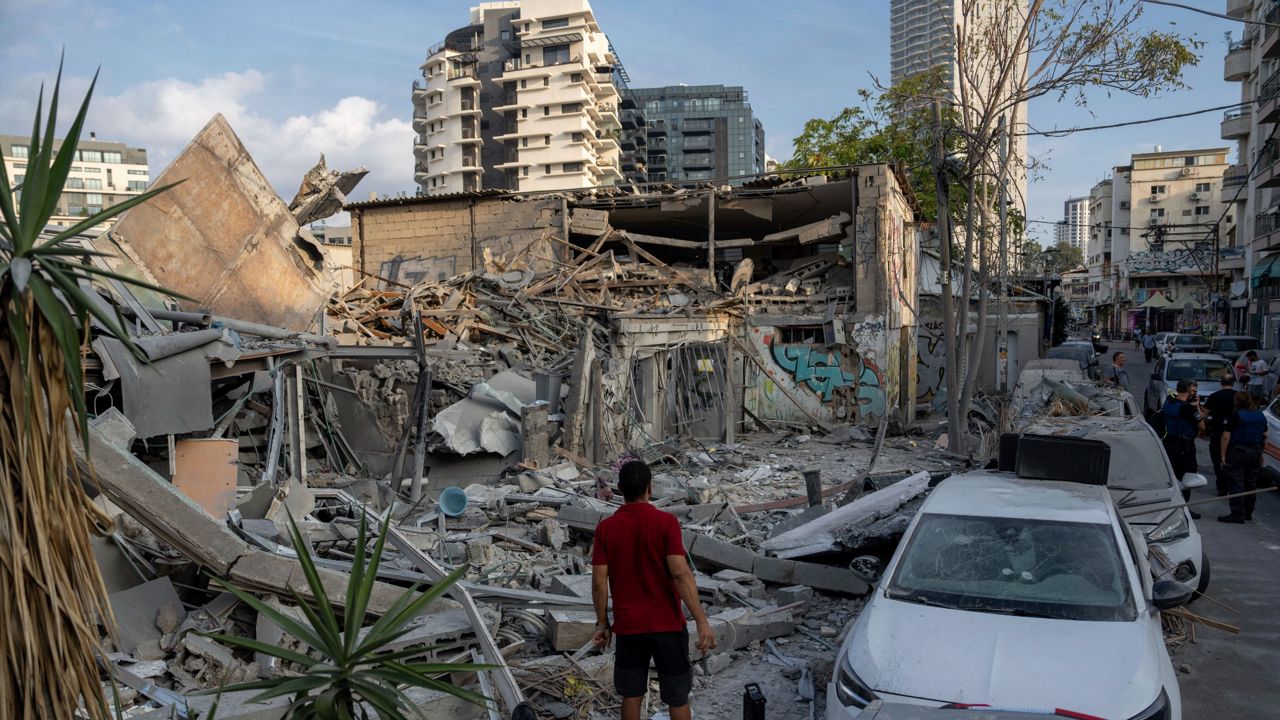 Israelis inspect the rubble of a building a day after it was hit by a rocket fired from the Gaza Strip, in Tel Aviv, Israel, Sunday, Oct. 8, 2023. The militant Hamas rulers of the Gaza Strip carried out an unprecedented, multi-front attack on Israel at daybreak Saturday, firing thousands of rockets as dozens of Hamas fighters infiltrated the heavily fortified border in several locations by air, land, and sea, killing hundreds and taking captives. (AP Photo/Oded Balilty)
