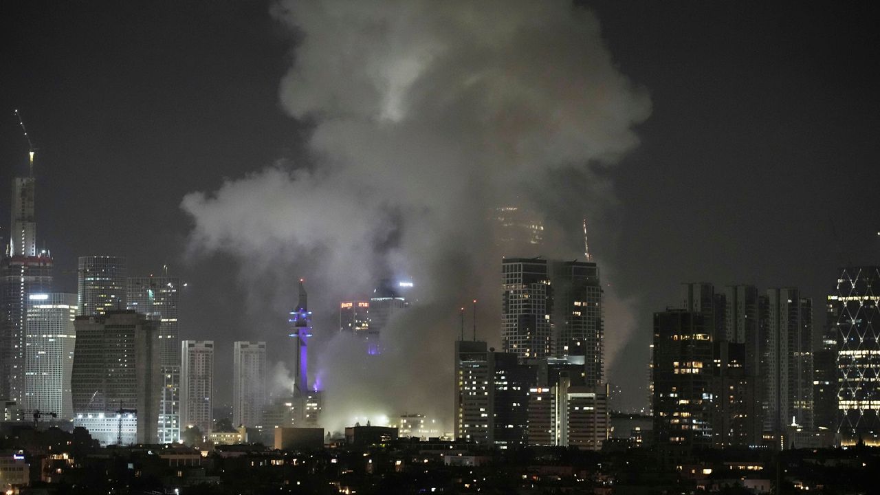 Smoke rises after a missile attack in Tel Aviv, Israel, Friday, June 13, 2025. (AP Photo/Leo Correa)