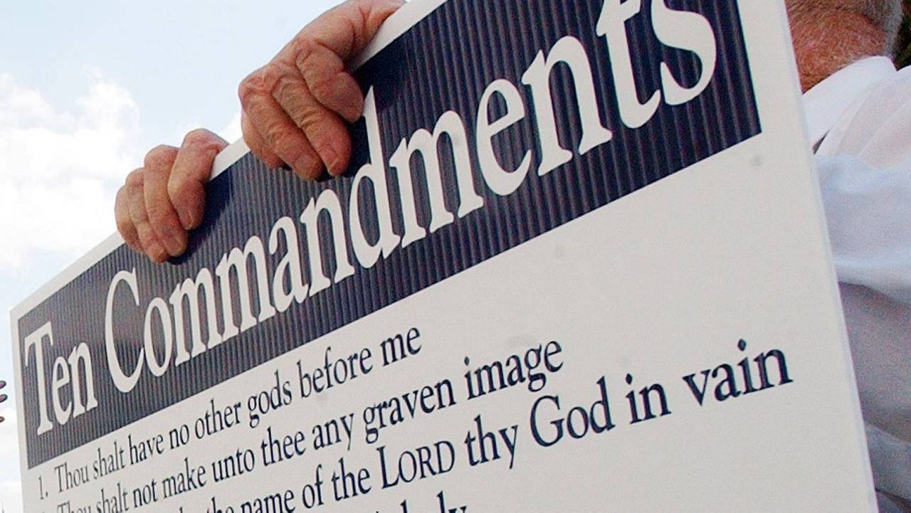 A protester holds a sign showing the The Commandments in Montgomery, Ala., Friday, Oct. 31, 2003. (AP Photo/Dave Martin, File)