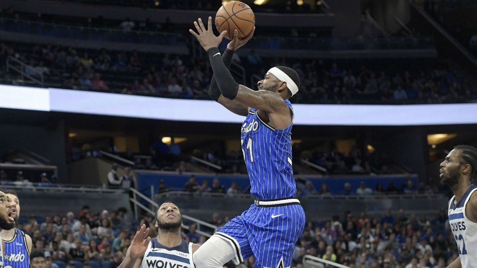 Orlando Magic guard Terrence Ross (31) goes up for a shot between Minnesota Timberwolves center Karl-Anthony Towns (32), guard Josh Okogie (20) and forward Andrew Wiggins (22) during the second half of an NBA basketball game Thursday, Feb. 7, 2019, in Orlando, Fla. (AP Photo/Phelan M. Ebenhack)