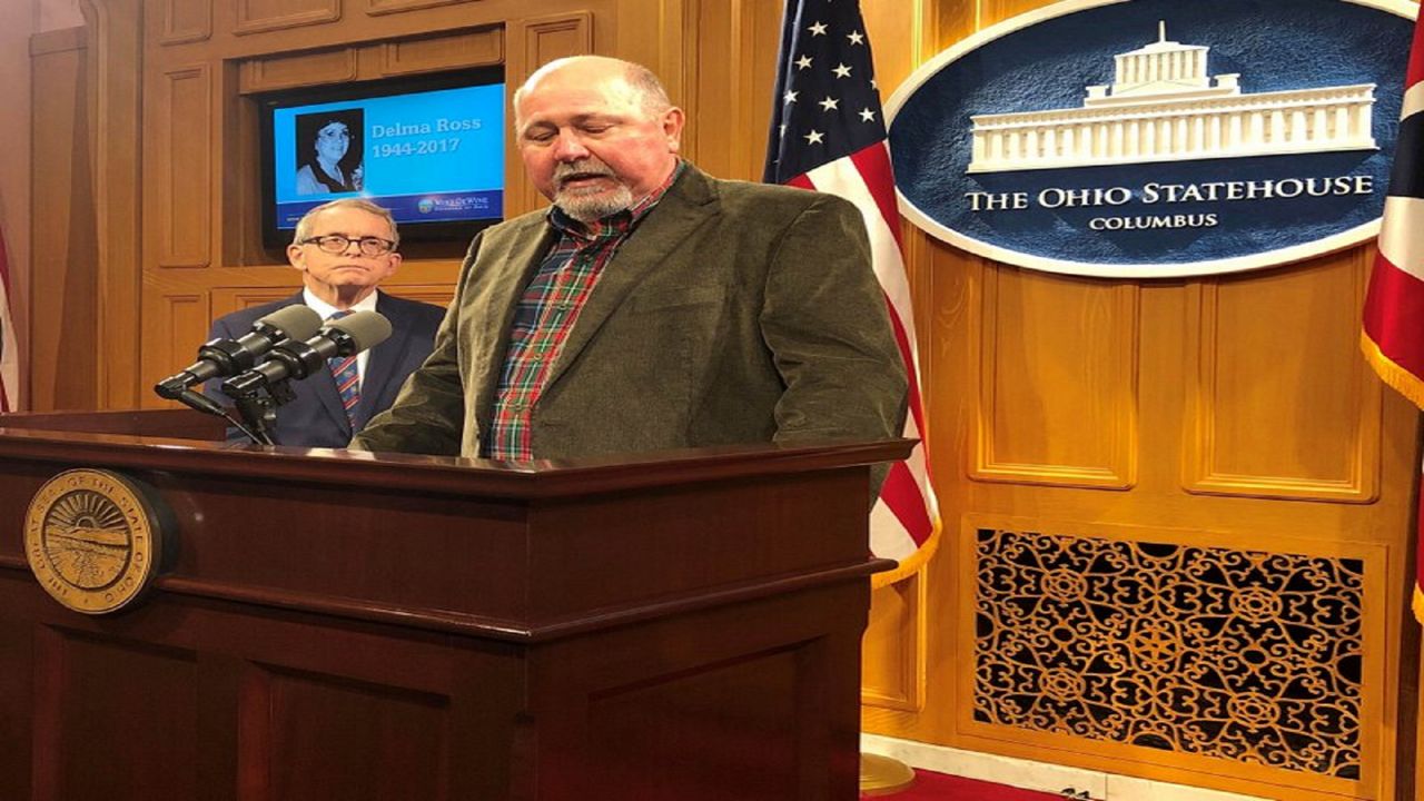 Terry Dawson, right, the son-in-law of a woman killed by a distracted driver in central Ohio on Christmas Eve 2017, describes how that accident has affected his family and made holidays much harder, at a news conference also attended by Ohio Gov. Mike DeWine, on Friday, Dec. 20, 2019, in Columbus, Ohio. DeWine said he wants distracted driving made a primary offense and promised a legislative proposal soon. (AP Photo/Andrew Welsh-Huggins)