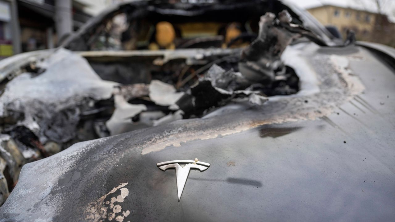 A burnt-out Tesla car stands in the Steglitz district of Berlin, Friday, March 14, 2025. (Christophe Gateau/dpa via AP)