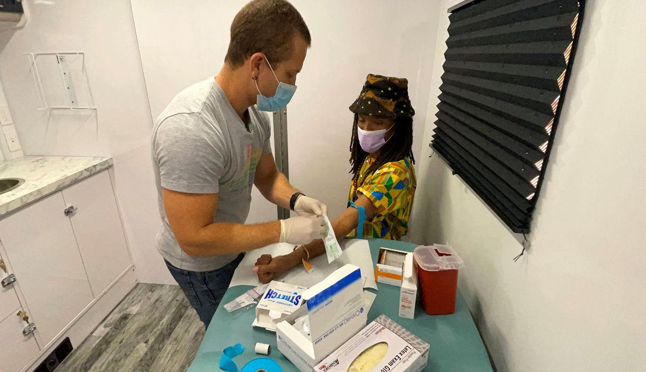 JP Cano performs an HIV test on Jalenzski Brown on SexyHealth mobile unit (Resource Center Dallas)
