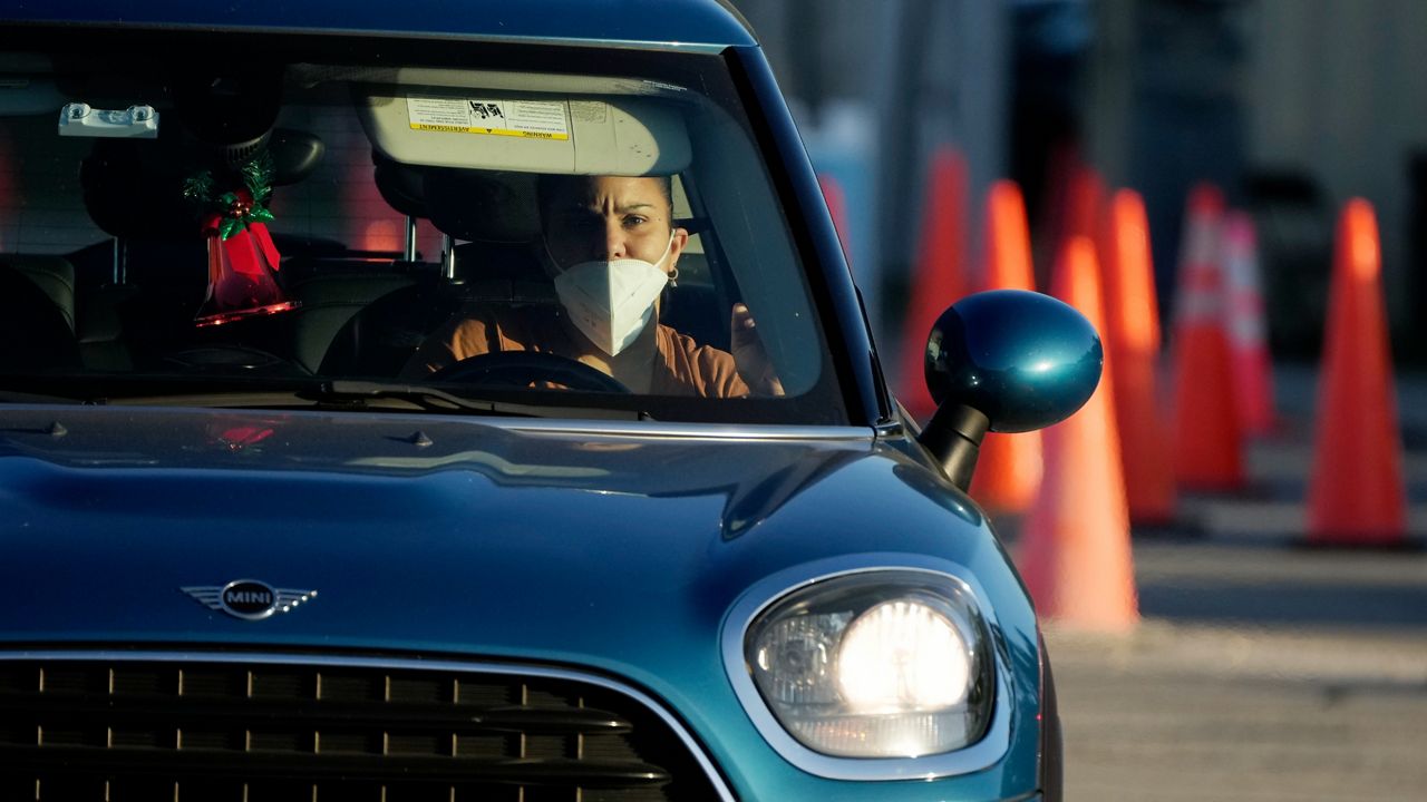 A woman waits in line to be tested for COVID-19 at a drive-up testing center. (AP/Rebecca Blackwell)