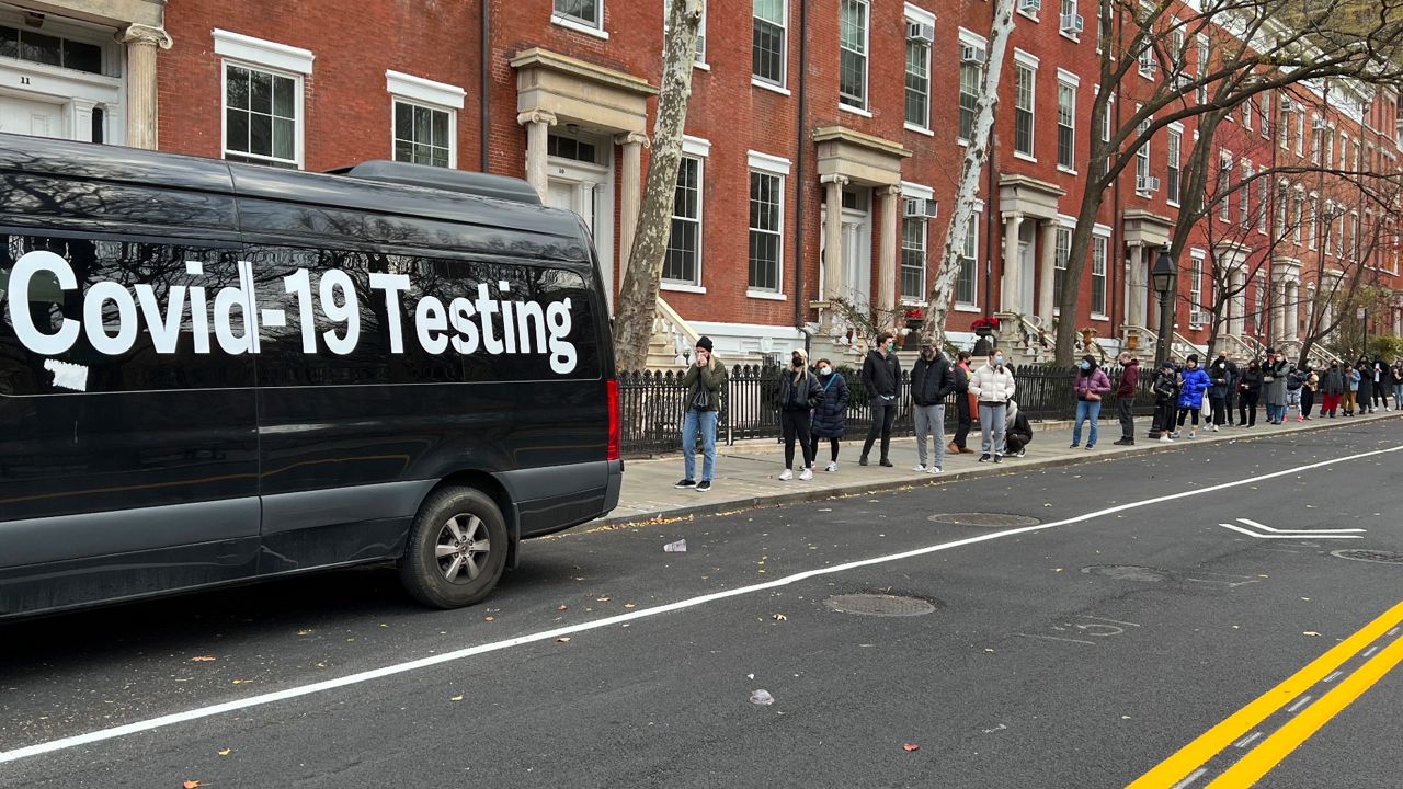 A line stretches down the block as people wait in line to be tested for COVID-19 across the street from Washington Square Park in Manhattan, on Thursday, Dec. 16, 2021. (AP Photo/Brooke Lansdale)