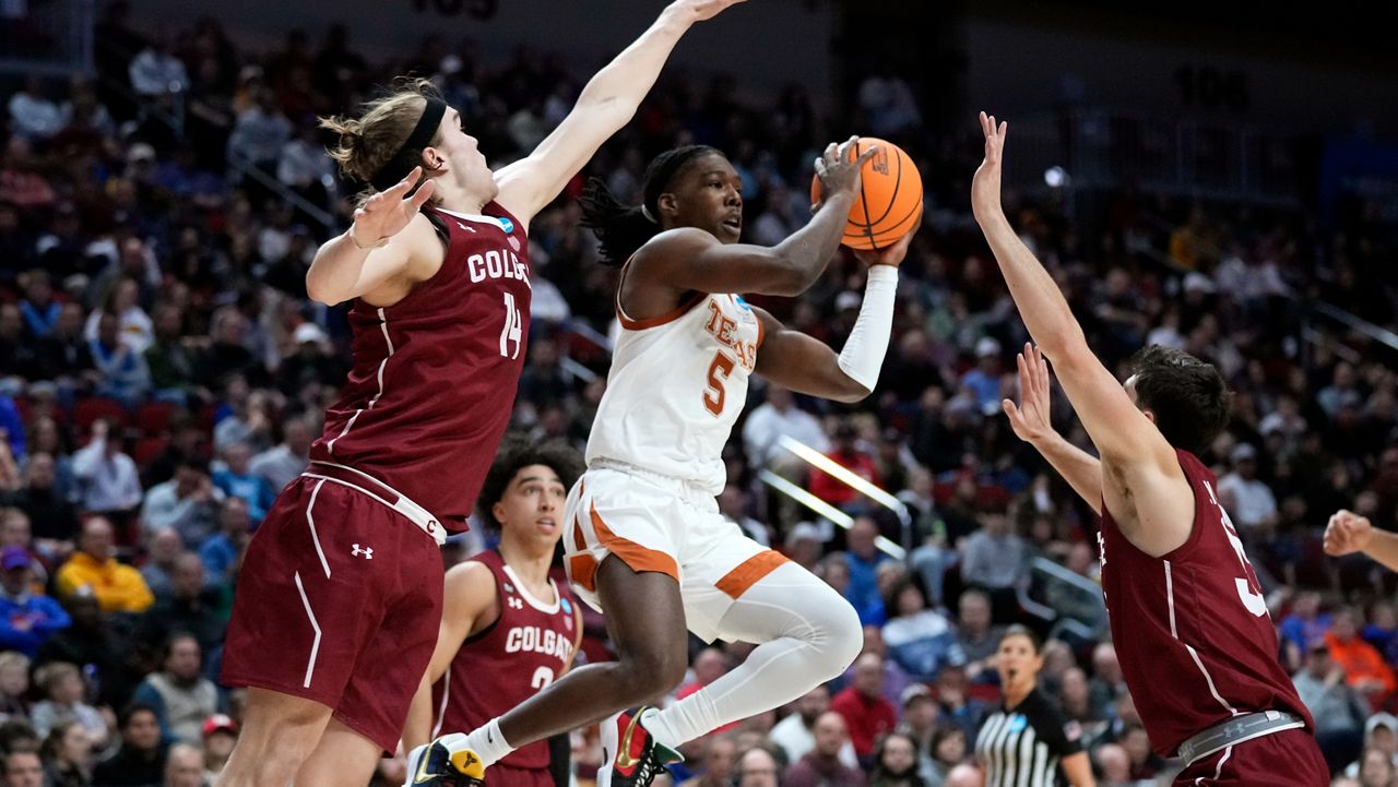 Texas guard Marcus Carr, center, passes between Colgate forward Keegan Records, left, and guard Oliver Lynch-Daniels, right, in the second half of a first-round college basketball game in the NCAA Tournament, Thursday, March 16, 2023, in Des Moines, Iowa. (AP Photo/Charlie Neibergall)