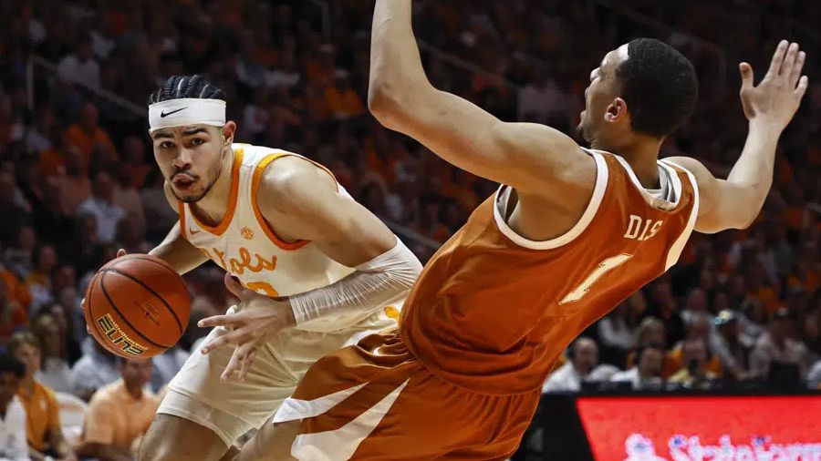 Texas forward Dylan Disu (1) falls as Tennessee forward Olivier Nkamhoua (13) collides with him during the first half of an NCAA college basketball game Saturday, Jan. 28, 2023, in Knoxville, Tenn. (AP Photo/Wade Payne)