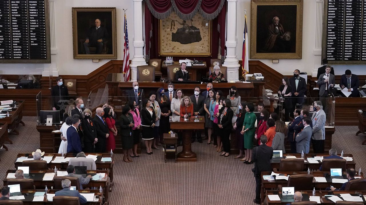 In this May 5, 2021, file photo, Texas state Rep. Donna Howard, center at lectern, stands with fellow lawmakers in the House chamber in Austin, Texas, as she opposes a bill to ban abortions as early as six weeks. (AP Photo/Eric Gay, File)