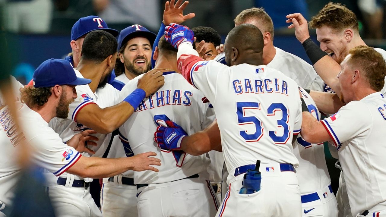 Texas Rangers' Mark Mathias, center, is welcomed at home plate by teammates after hitting a game-ending home run in the team's 8-7 win in a baseball game against the Oakland Athletics in Arlington, Texas, Tuesday, Sept. 13, 2022. (AP Photo/Tony Gutierrez)