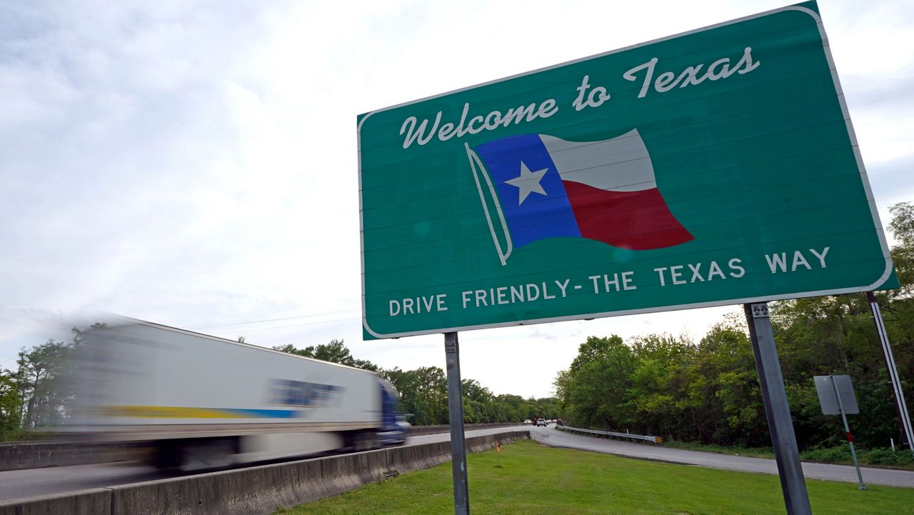 A truck passes a welcome sign along I-10 Sunday, March 29, 2020, in Orange, Texas, near the Louisiana border. (AP Photo/David J. Phillip)