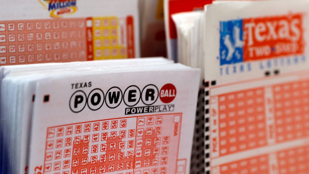 A play slip for the Power Ball lottery sits in a holder at a convenient store in Dallas, Thursday March 26, 2020. Lottery jackpots are going to shrink as the coronavirus pandemic tamps down lottery sales. The group that oversees the Powerball game announced Wednesday night that it would cut minimum jackpots in half. (AP Photo/Tony Gutierrez)