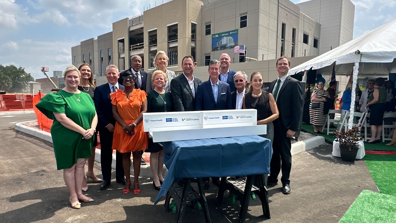 State and local leaders pose as the completion of its new behavioral health teaching center nears completion. (Spectrum News/Lizbeth Gutierrez)