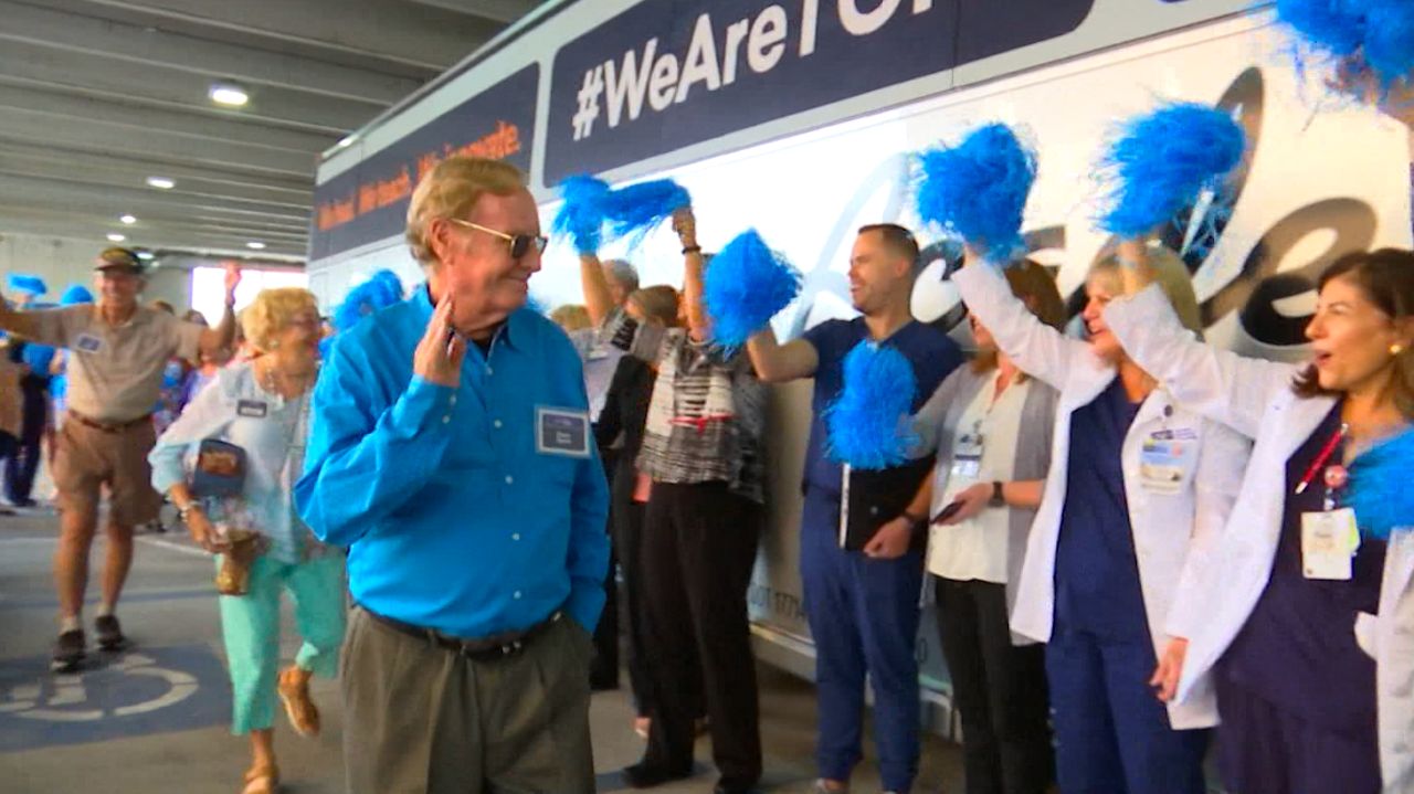 Hospital staff greet patient advocates as they board buses to Tallahassee. (Adria Iraheta/Spectrum Bay News 9)