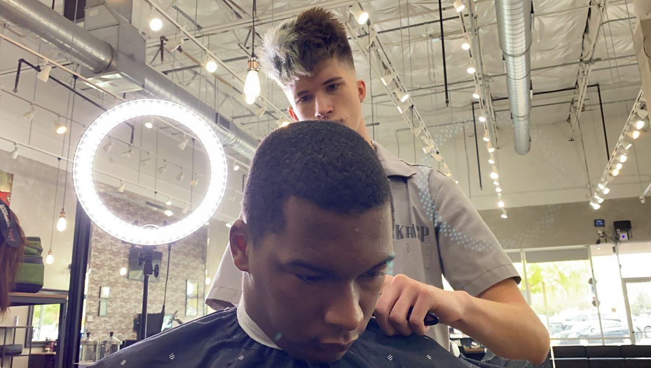 John Giesey gives a haircut in this image from November 2021. (Spectrum News 1/Michael Lozano)