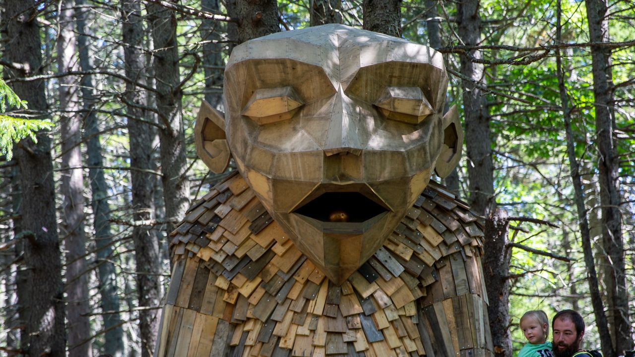 People visit Gro, a giant troll sculpture made from recycled wood by Danish artist Thomas Dambo, at the Coastal Maine Botanical Gardens in Boothbay, Maine, on Sunday, August 15, 2021. (AP Photo/Ted Shaffrey)