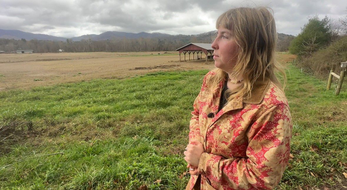 Lily Fidler, a senior at Warren Wilson College, looks at the student-run farm that was severely damaged by Hurricane Helene in late September. (Spectrum News 1/Jennifer Roberts)