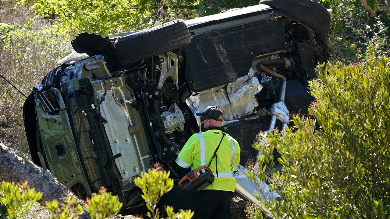 In this Feb. 23, 2021 file photo, a vehicle rests on its side after a rollover accident involving golfer Tiger Woods, in Rancho Palos Verdes, Calif., a suburb of Los Angeles. (AP Photo/Marcio Jose Sanchez)