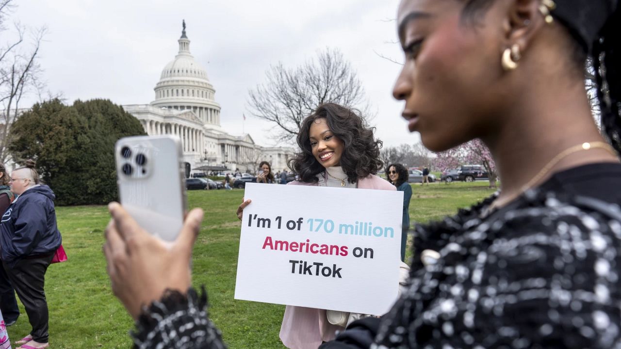 Devotees of TikTok, Mona Swain, center, and her sister, Rachel Swain, right, both of Atlanta, pose with a sign at the Capitol in Washington, March 13, 2024. TikTok's extensive lobbying campaign is the latest tech industry push since the House passed legislation that would ban the popular app if its China-based owner doesn't sell its stake. TikTok has been urging its users to call their representatives. (AP Photo/J. Scott Applewhite, File)