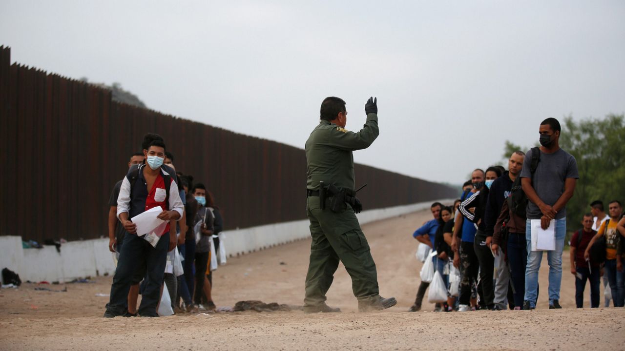 A Border Patrol agent instructs migrants who had crossed the Rio Grande river into the U.S. in Eagle Pass, Texas, Friday, May 20, 2022. (AP Photo/Dario Lopez-Mills)
