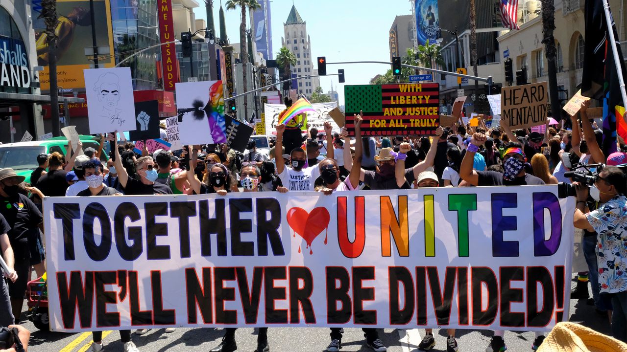 Protesters hold up a sign at the start of the the All Black Lives Matter march, organized by black LGBTQ+ leaders, on Sunday, June 14, 2020, in Los Angeles. (AP Photo/Paula Munoz)