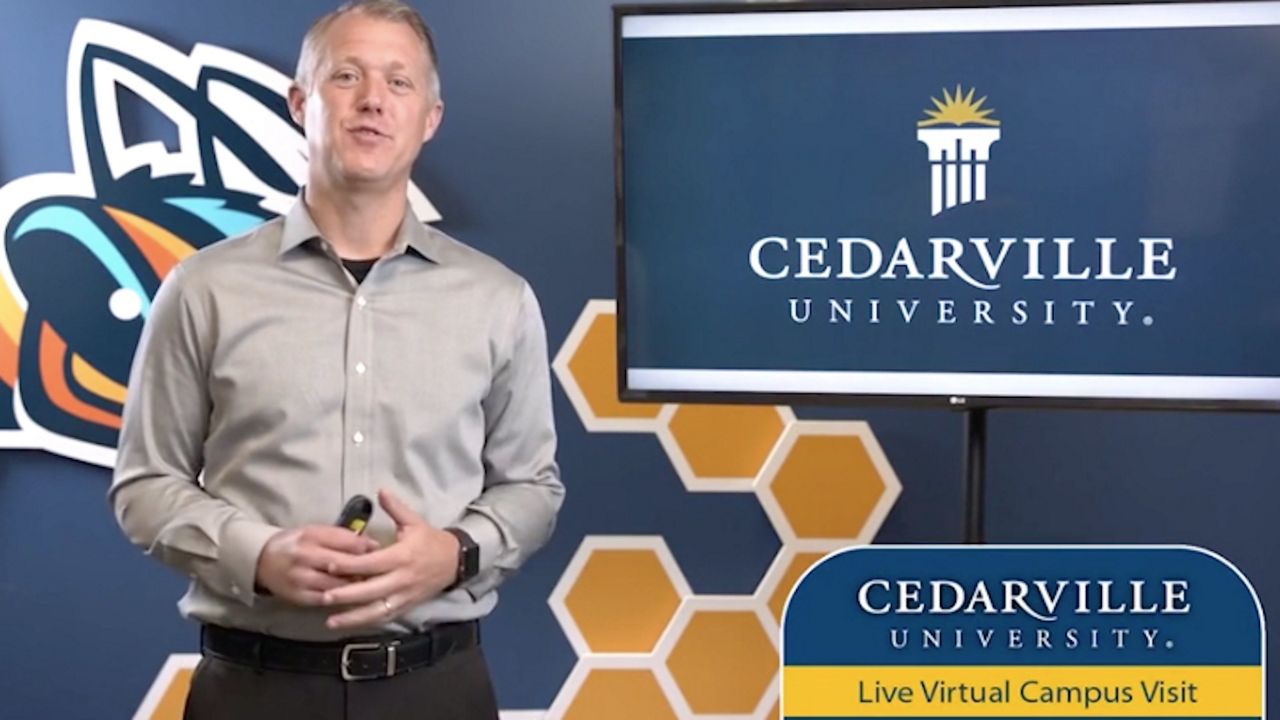 Man standing in front of screen that says Cedarville Virtual Tour