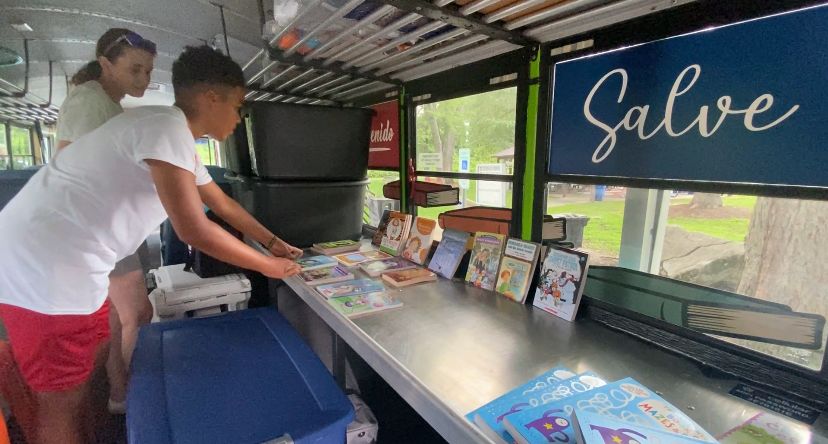 Tommy arranges books on the Blue Bear Bus