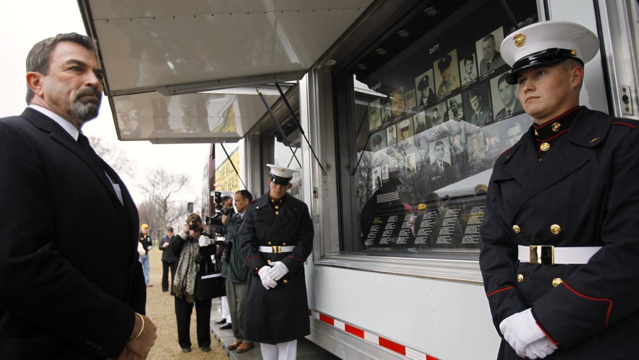 Actor Tom Selleck, left, attends an event unveiling a traveling exhibit called "The Wall That Heals", part of the traveling Vietnam Veterans Memorial and Museum, in Washington, Thursday, March 26, 2009. At right is U.S. Marine Corps Lance Cpl. Nick Adams, 21. (AP Photo/Jacquelyn Martin)