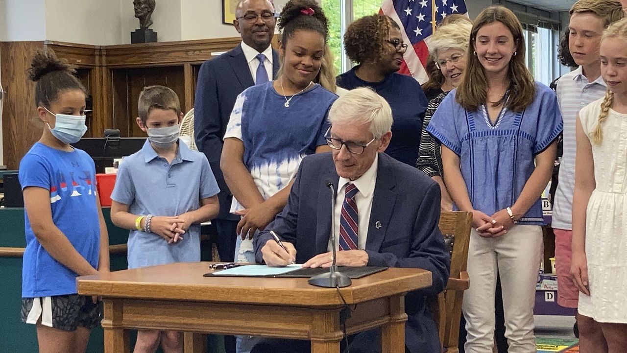 Democratic Wisconsin Gov. Tony Evers signs the Republican-written state budget that includes a $2 billion income tax cut at Cumberland Elementary School, Thursday, July 8, 2021, in Whitefish Bay, Wis.