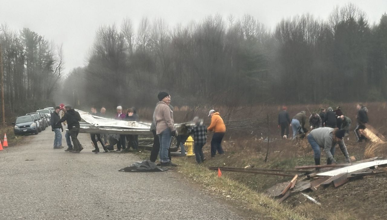 People work to clean up debris from a tornado in Jefferson Township, Ohio.