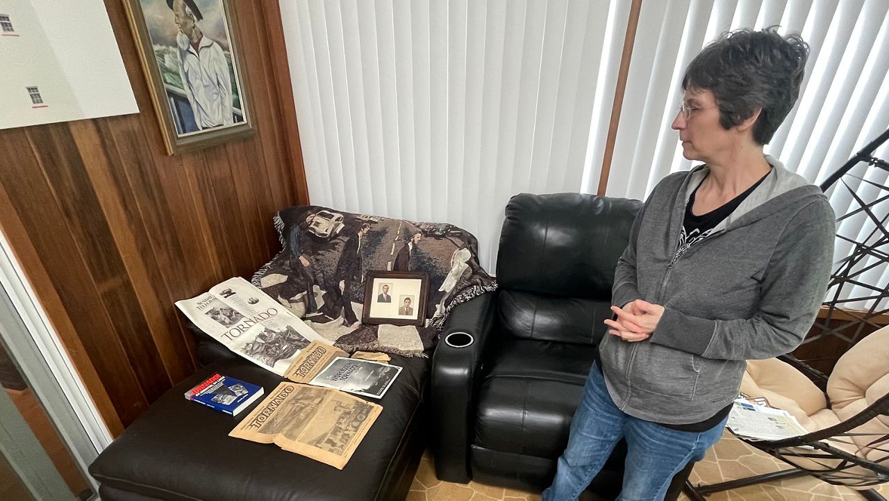 Kathy Lundstrom looks at old newspaper clippings from the deadly 1953 tornado. (Spectrum News 1/Andrew Boucher)