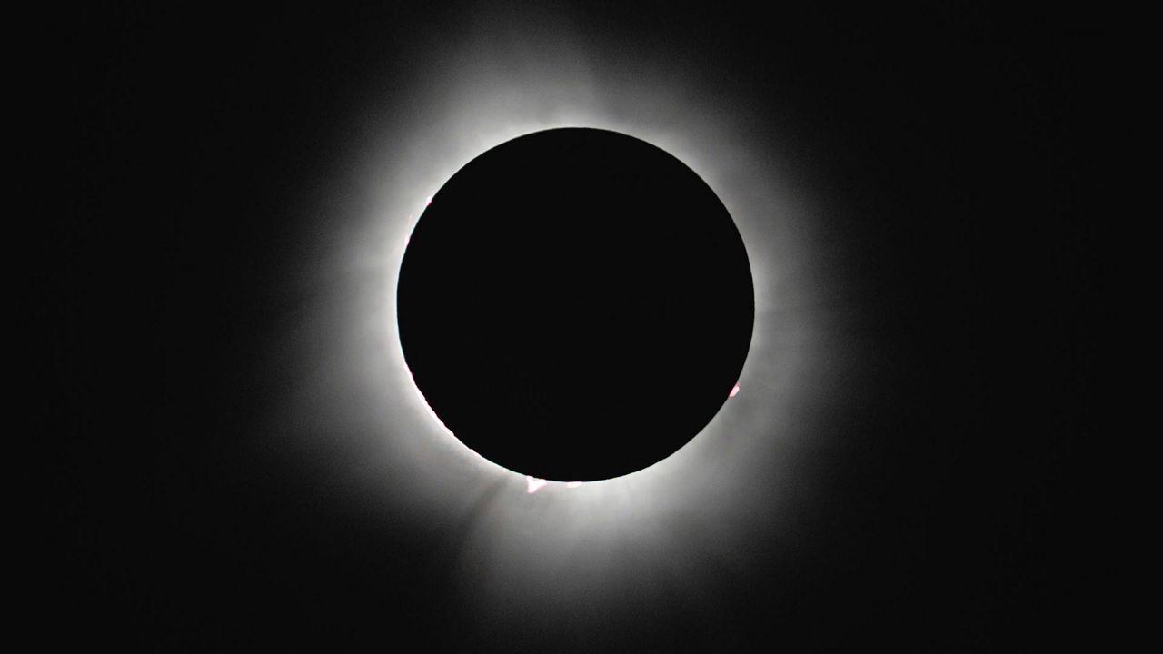 Totality is seen during a solar eclipse during a mass wedding ceremony at Trenton Community Park, Monday, April 8, 2024, in Trenton, Ohio. (AP Photo/Jon Cherry)