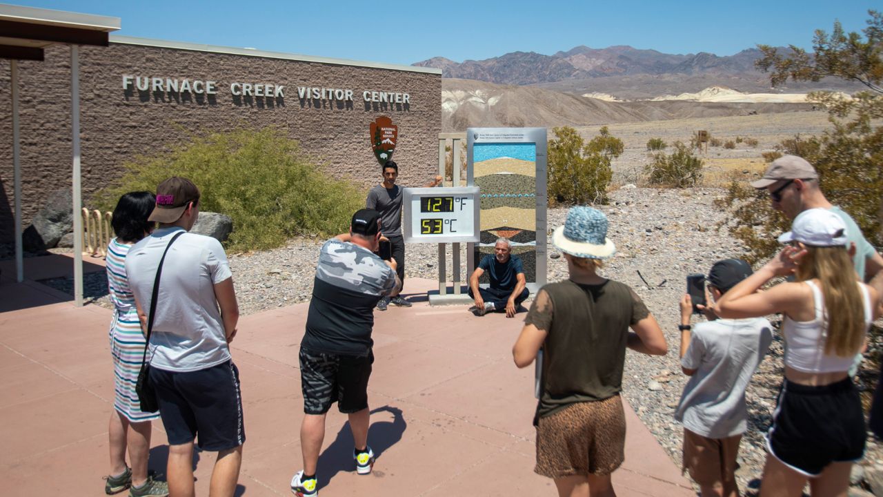 Tourists take photos in front of the Furnace Creek visitor center thermometer on Monday in Death Valley National Park, Calif.  (Daniel Jacobi II/Las Vegas Review-Journal via AP)