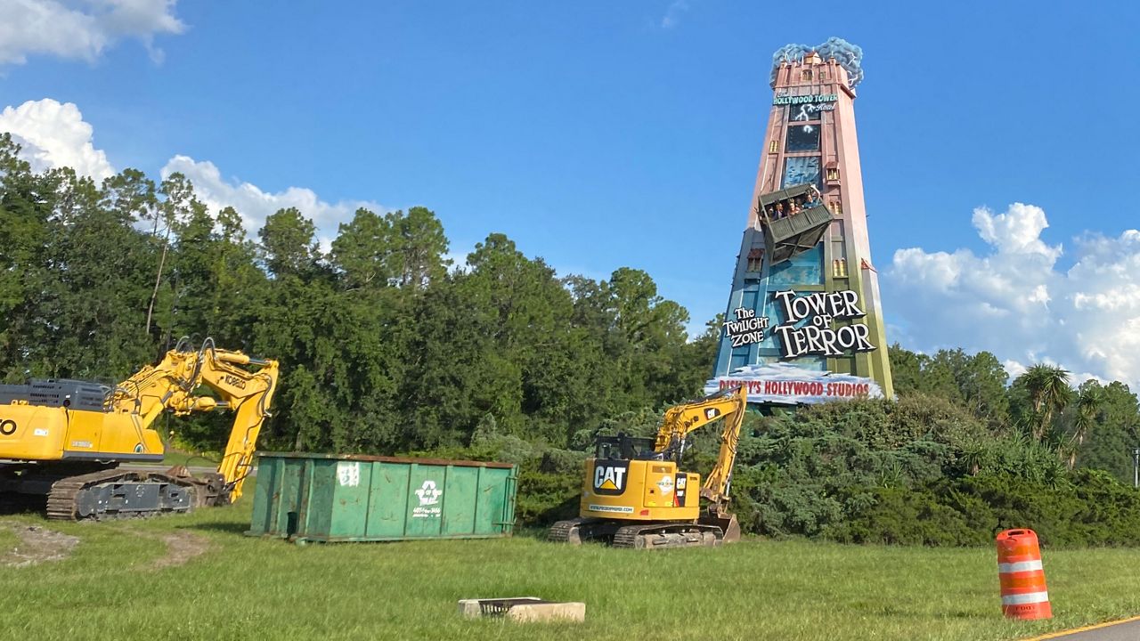 Excavators prepare to remove Disney's Tower of Terror billboard along World Drive Wednesday. (Spectrum News 13/Ashley Carter)