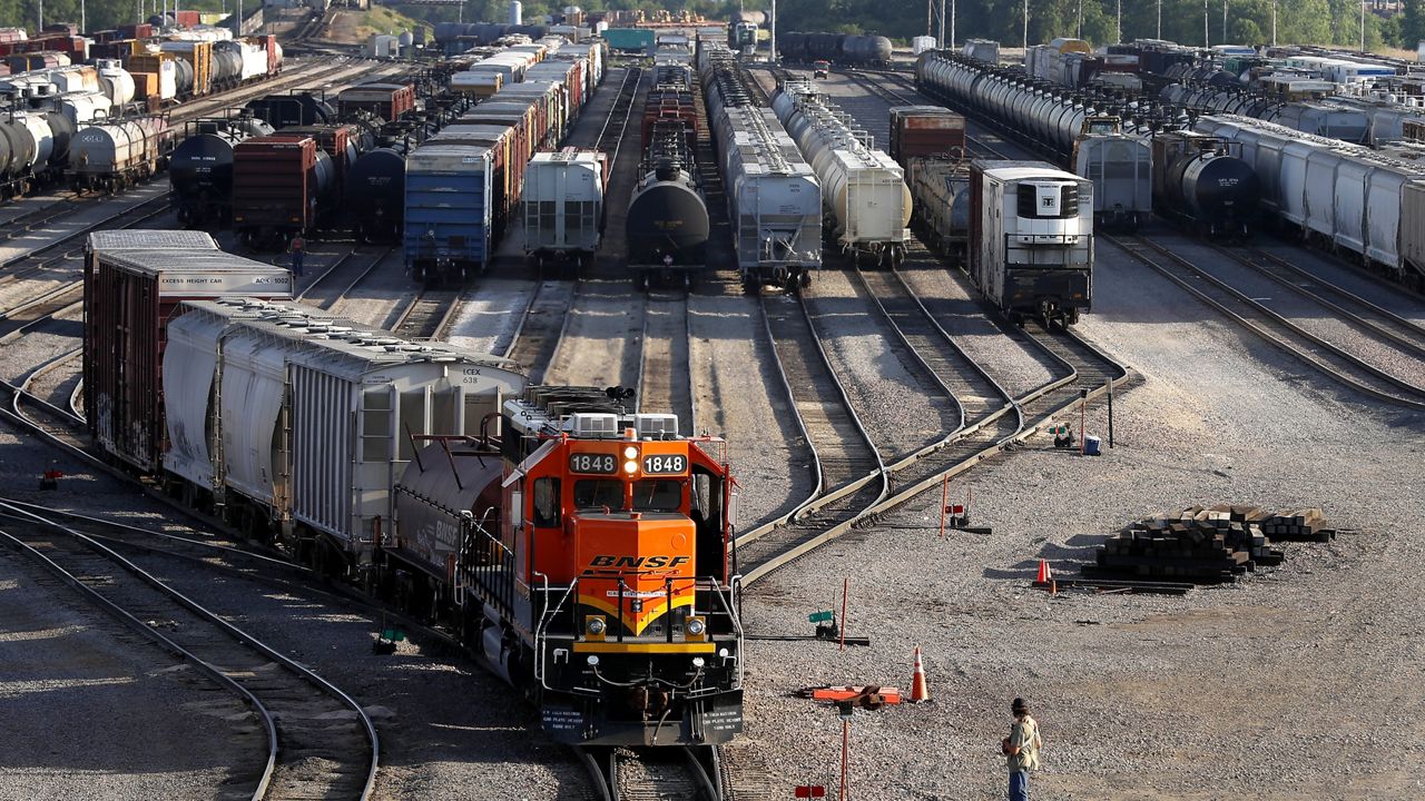 A BNSF rail terminal worker monitors the departure of a freight train, on June 15, 2021, in Galesburg, Ill. (AP Photo/Shafkat Anowar, File)