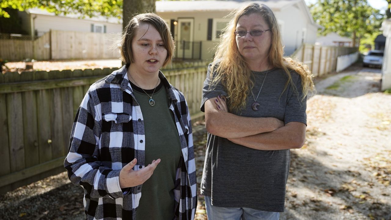 Caston Peters and their mom, Kim Michaelis-Peters, speak about restricting students from using pronouns or names that don't match their sex assigned at birth, Friday, Oct. 6, 2023, in Indianapolis.(AP Photo/Darron Cummings)