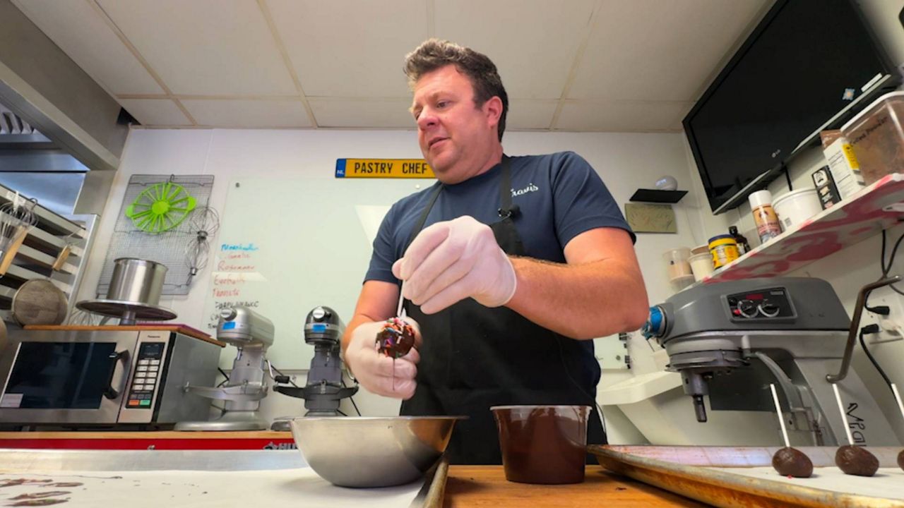 Travis Roy, one of the Cortez Stone Crab & Music Festival vendors, works at his business, Breezy Bakery, in Cortez. (Spectrum News/Julia Hazel)